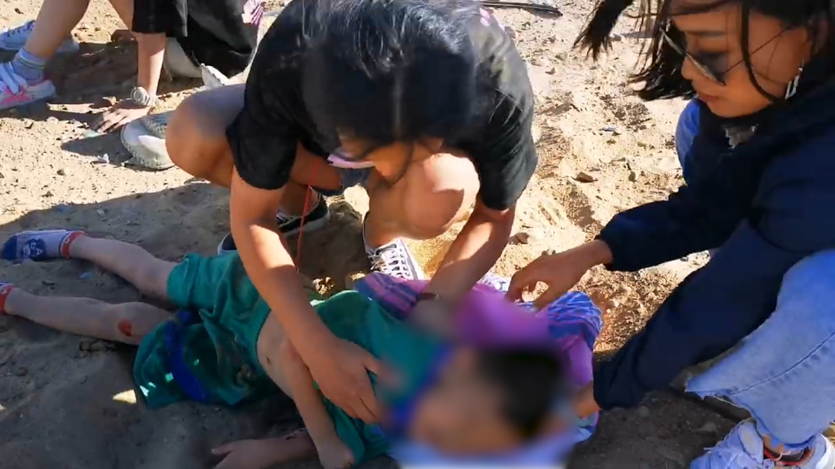 女子连人带车翻下沙漠公路，河南游客飞奔营救，9岁男孩举毛毯为伤者遮阳